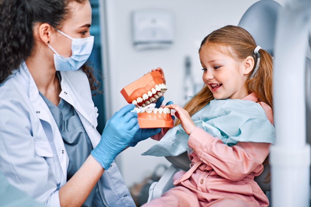 Children's,Dentistry.,Cropped,Image,Of,Child,And,Nurse,Holding,Mockup
