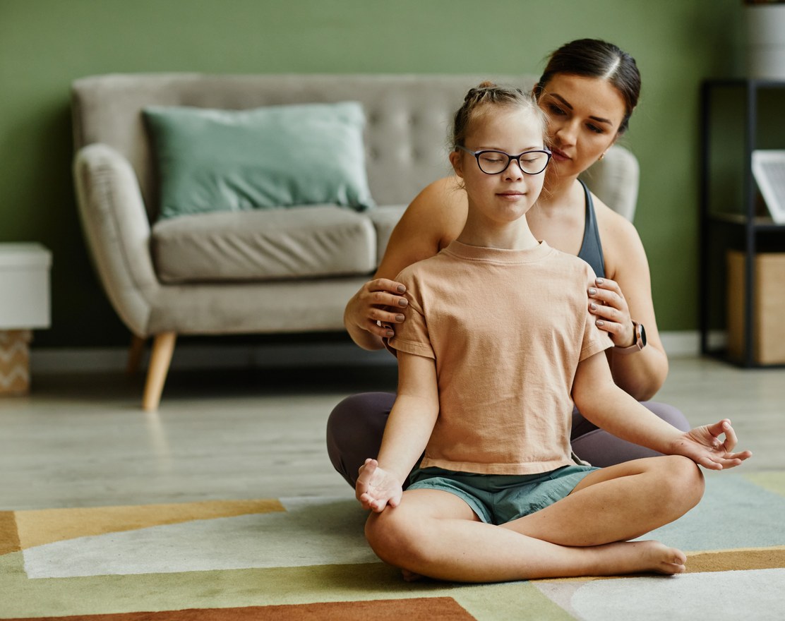 A therapist sitting behind a child during a session
