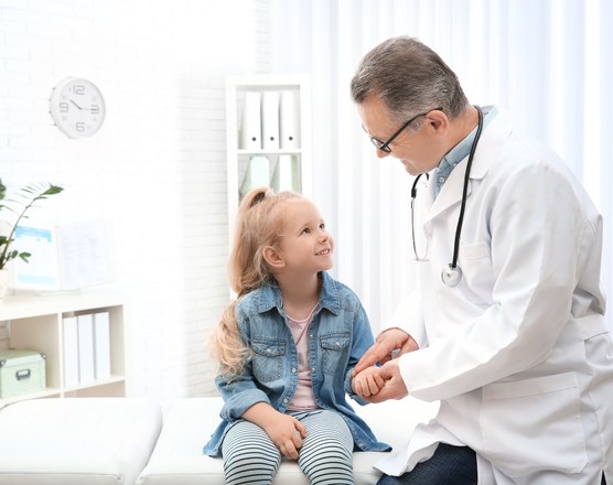 A doctor examining a young girl during a clinic appointment