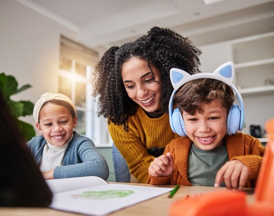 A mother and two children at a table, one wearing ear defenders