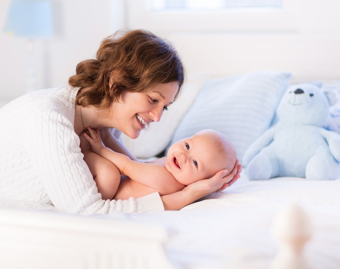 A mother holding her newborn baby against her shoulder