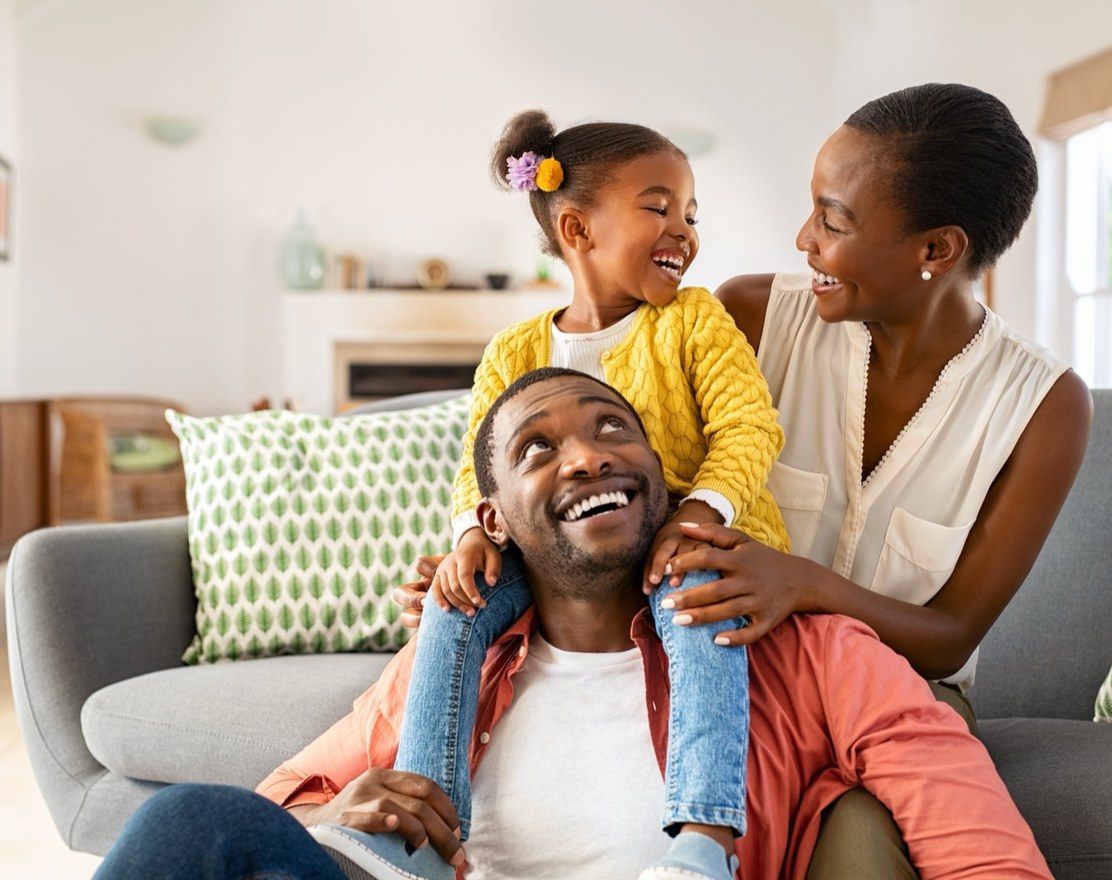 A family sitting together on a sofa, laughing