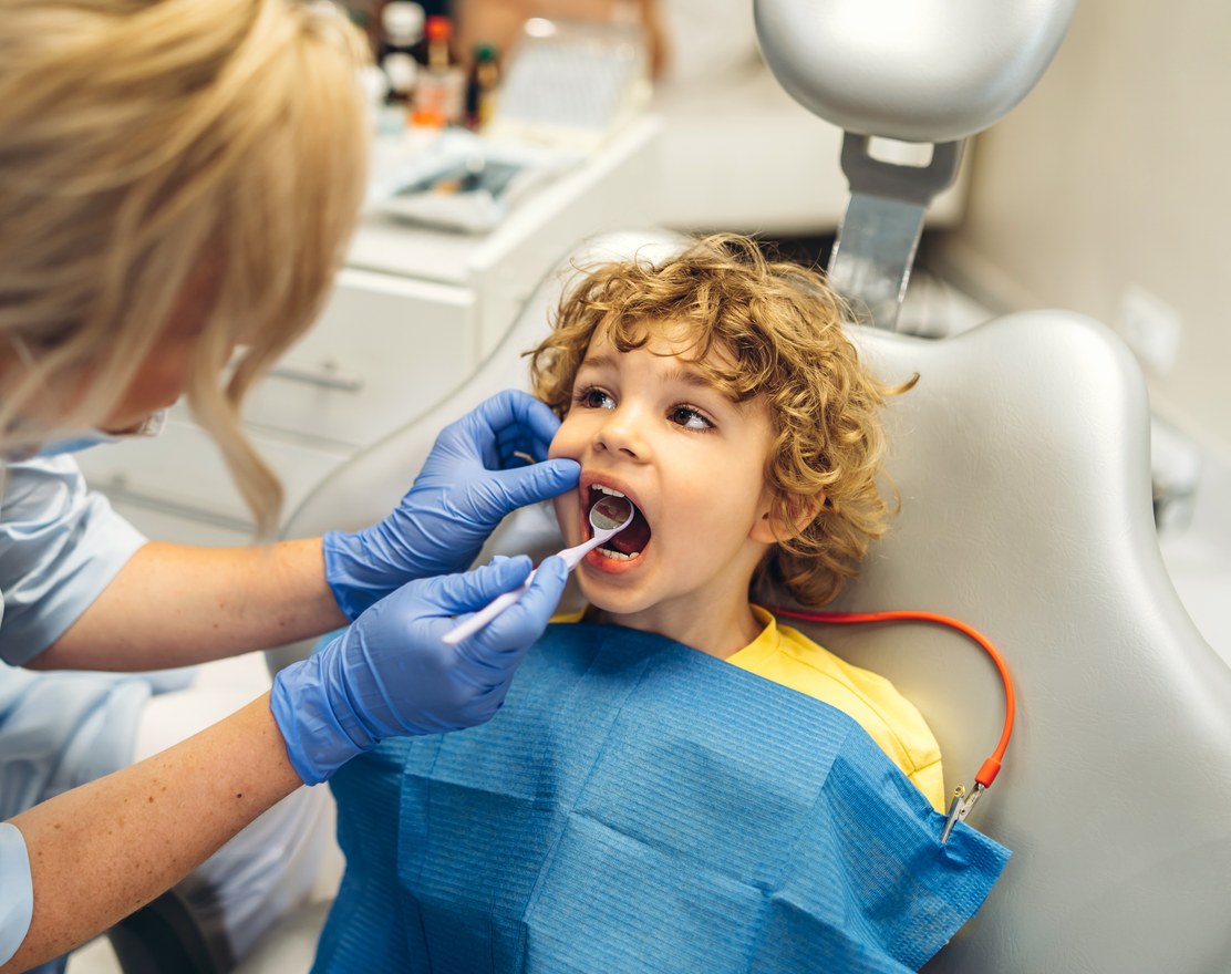 A dentist examining a young boy's teeth