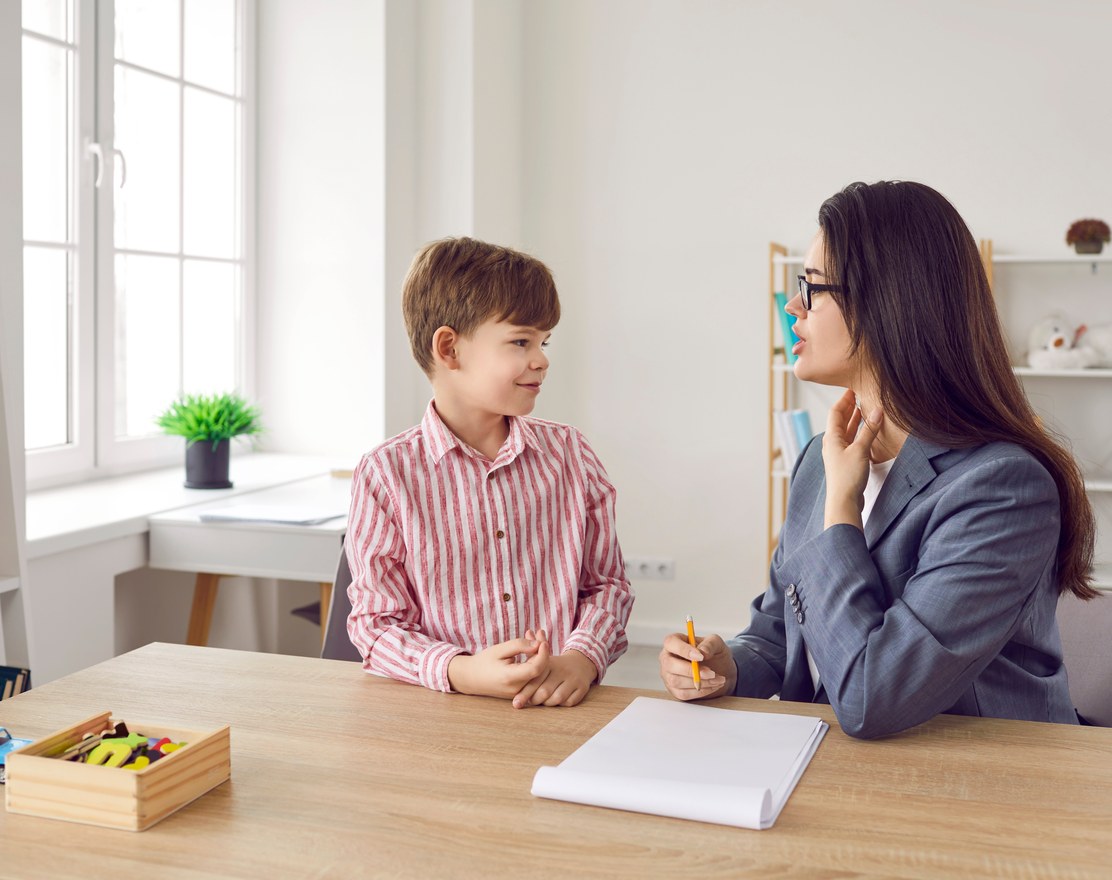 A child at a table with a clinician during an assessment
