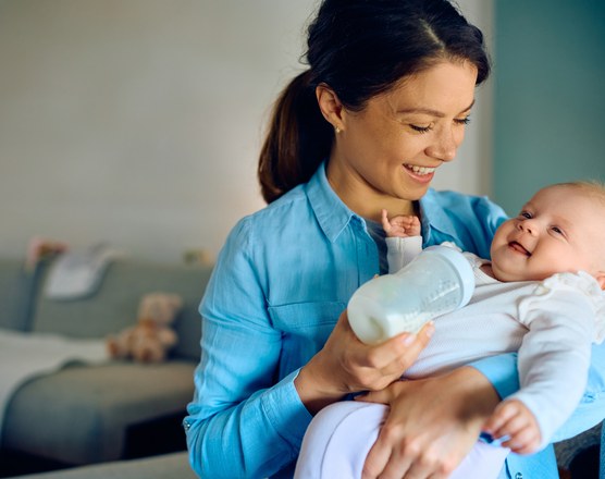 A mother holding and bottle-feeding her baby