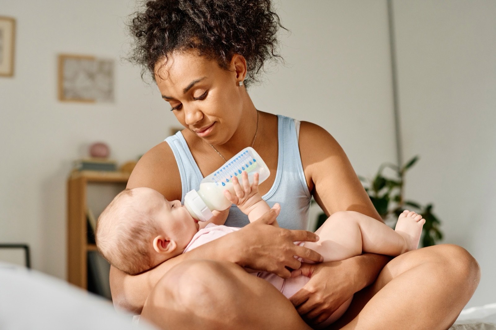 A mother bottle-feeding her newborn