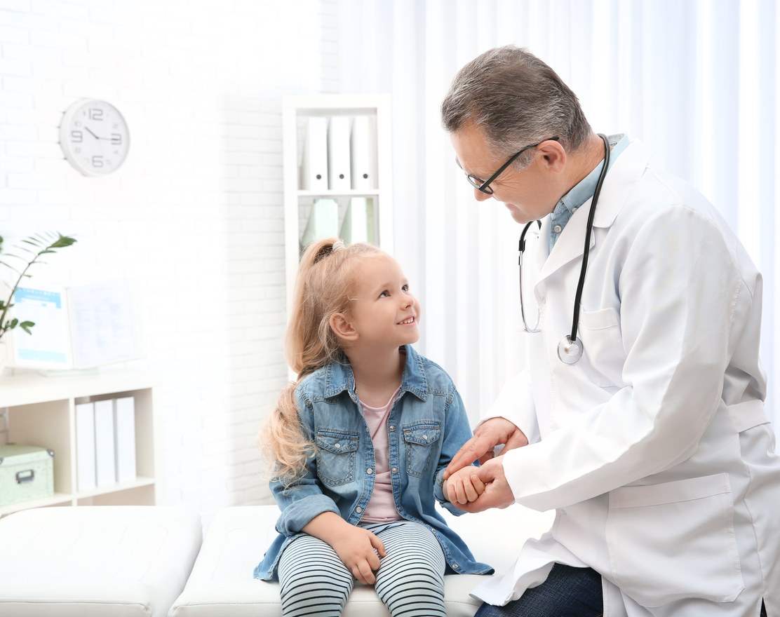 A clinician examining a young girl in a consulting room