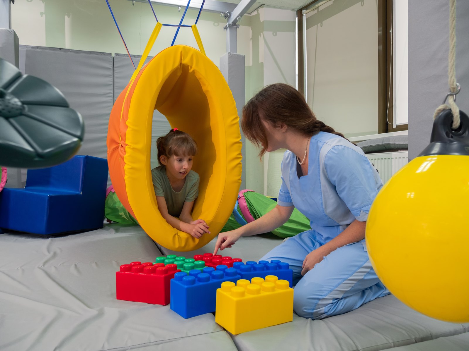 A young child crawling through a fabric play tunnel